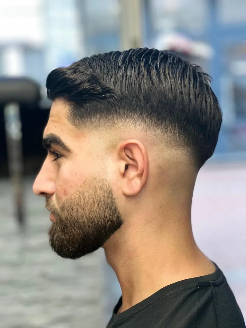 Kunde im Profil mit frischem Fade und konturiertem Bart